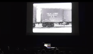 a dark theatre with a audience watching a silent black and white film